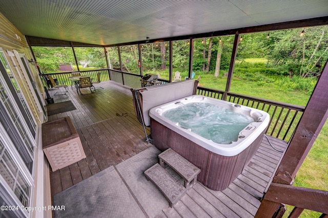 wooden deck with outdoor dining space, a lawn, and a hot tub