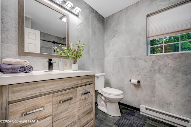 bathroom featuring tile walls, a baseboard radiator, toilet, vanity, and walk in shower