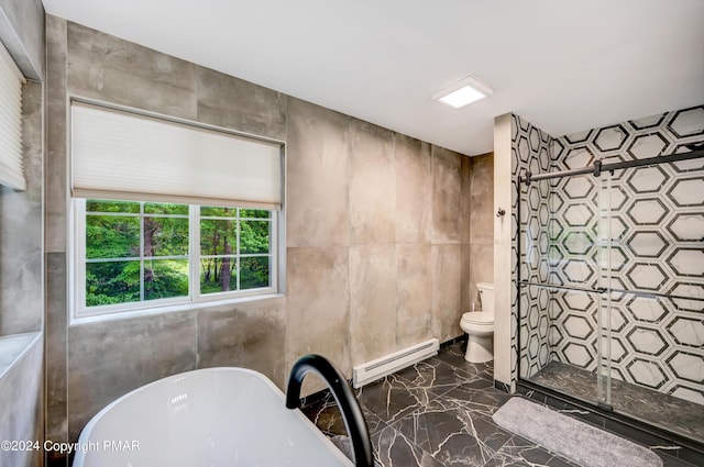 bathroom featuring toilet, marble finish floor, baseboard heating, a freestanding bath, and a shower stall