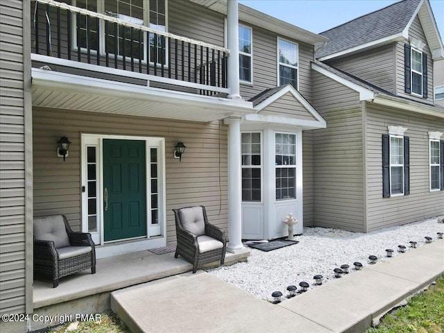 doorway to property featuring a porch and a balcony