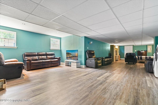 living room with a drop ceiling, baseboards, and wood finished floors