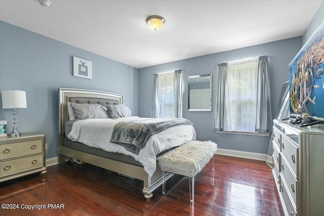 bedroom with dark wood-type flooring and baseboards