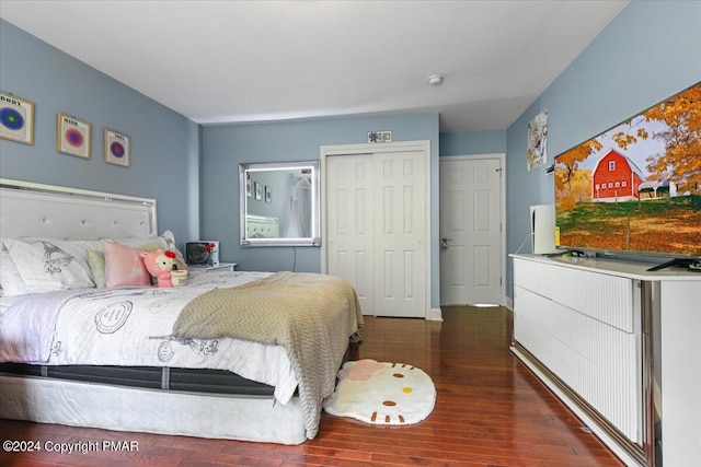 bedroom with wood finished floors, a closet, and baseboards