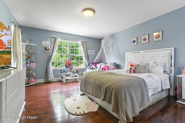 bedroom with baseboards and hardwood / wood-style floors