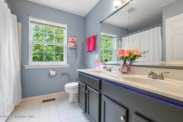 bathroom with double vanity, toilet, visible vents, and a sink