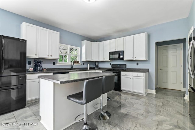 kitchen featuring white cabinetry, black appliances, dark countertops, and a center island