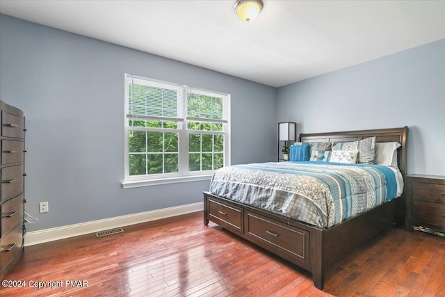 bedroom featuring hardwood / wood-style floors, baseboards, and visible vents