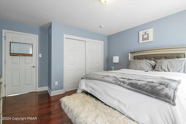 bedroom with a closet, baseboards, and wood finished floors