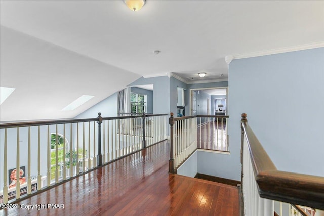 hall featuring a healthy amount of sunlight, crown molding, baseboards, and wood-type flooring