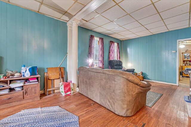 213 N St Fran Cabrini Ave, Scranton, PA 18504 - living room featuring ornate columns, a paneled ceiling, wood finished floors, and wood walls
