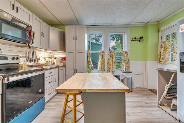 213 N St Fran Cabrini Ave, Scranton, PA 18504 - kitchen featuring stainless steel electric range, black microwave, wood counters, light wood-style flooring, and white cabinetry