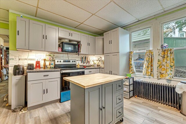 213 N St Fran Cabrini Ave, Scranton, PA 18504 - kitchen featuring range with electric cooktop, black microwave, a drop ceiling, radiator, and wooden counters