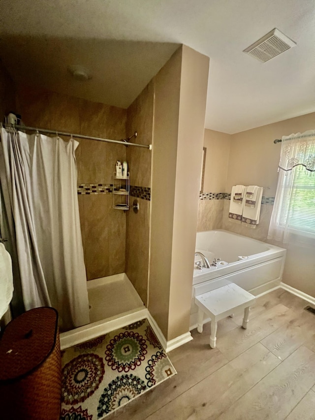 512 Bombur Ln, Tamiment, PA 18371 - full bathroom with a garden tub, a shower stall, wood finished floors, and baseboards