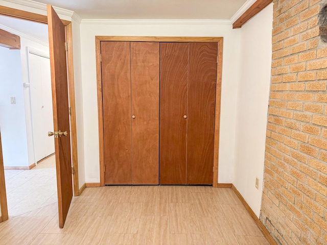 4751 Brentwood Dr, Tobyhanna, PA 18466 - unfurnished bedroom with brick wall, crown molding, a closet, and baseboards
