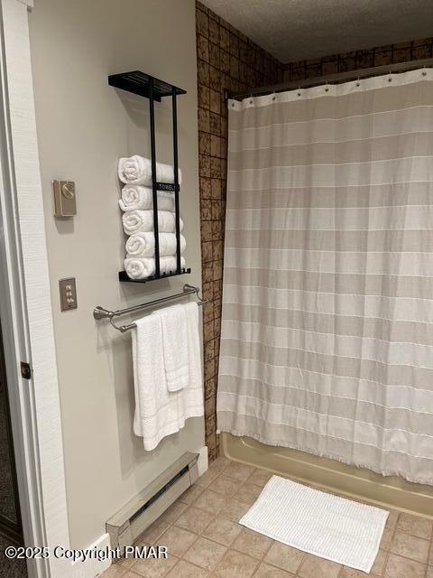 full bathroom with a baseboard heating unit, shower / tub combo, a textured ceiling, and tile patterned floors