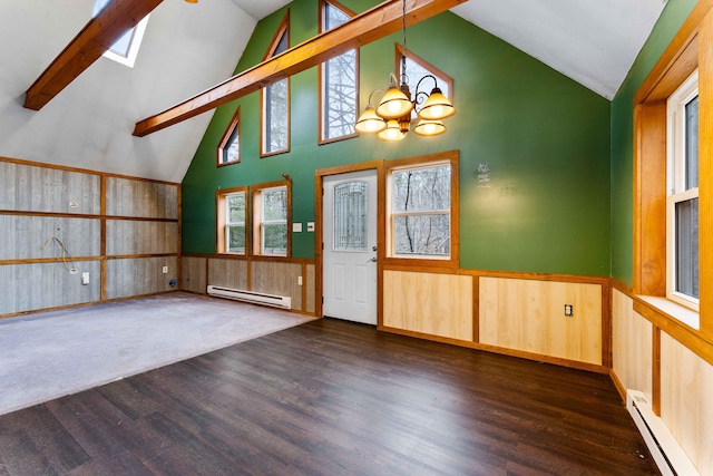 interior space featuring a wainscoted wall, lofted ceiling with skylight, and baseboard heating