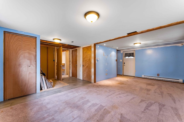 spare room featuring a baseboard heating unit and carpet