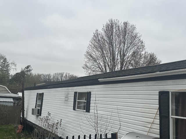 view of property exterior featuring a shingled roof and cooling unit