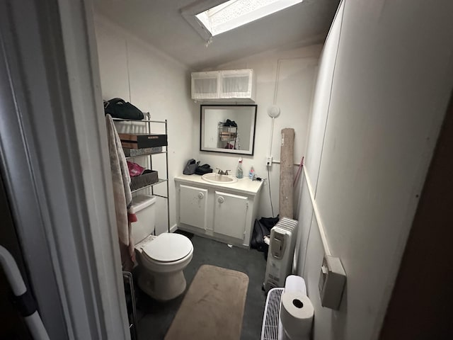 bathroom featuring vaulted ceiling, vanity, toilet, and a skylight