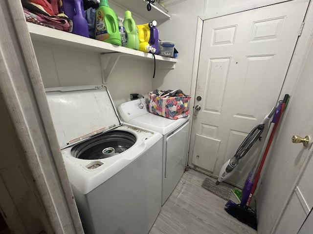 laundry room featuring washer and clothes dryer and light wood-type flooring