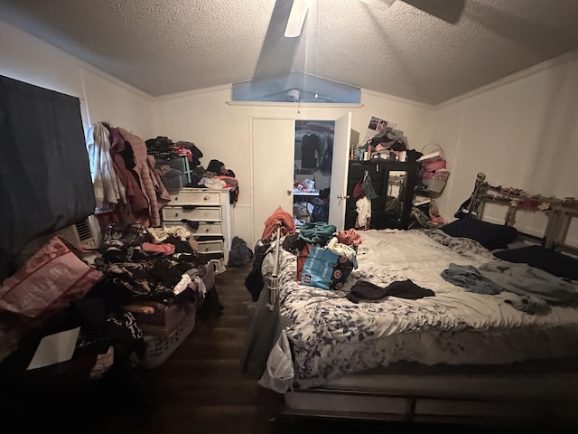 bedroom with a textured ceiling, wood finished floors, and a ceiling fan