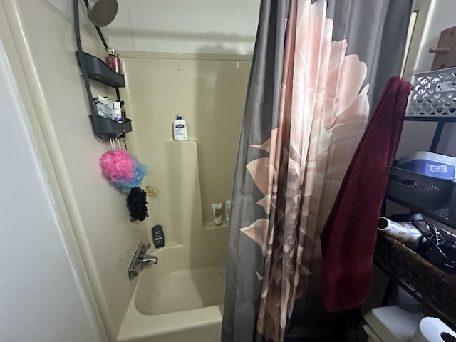 bathroom with shower / bath combo and toilet