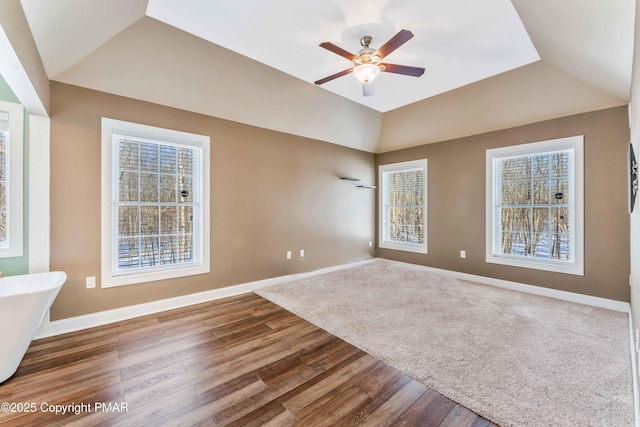 unfurnished room with vaulted ceiling, wood finished floors, a ceiling fan, and baseboards