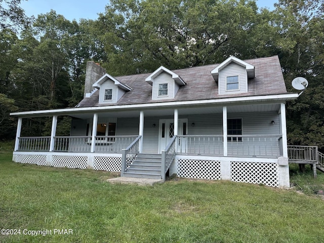 view of front of house with a porch, a chimney, and a front lawn