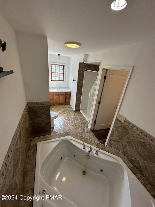 full bathroom featuring a tub with jets and a sink