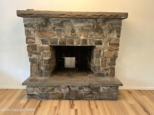 interior details featuring a fireplace, baseboards, and wood finished floors