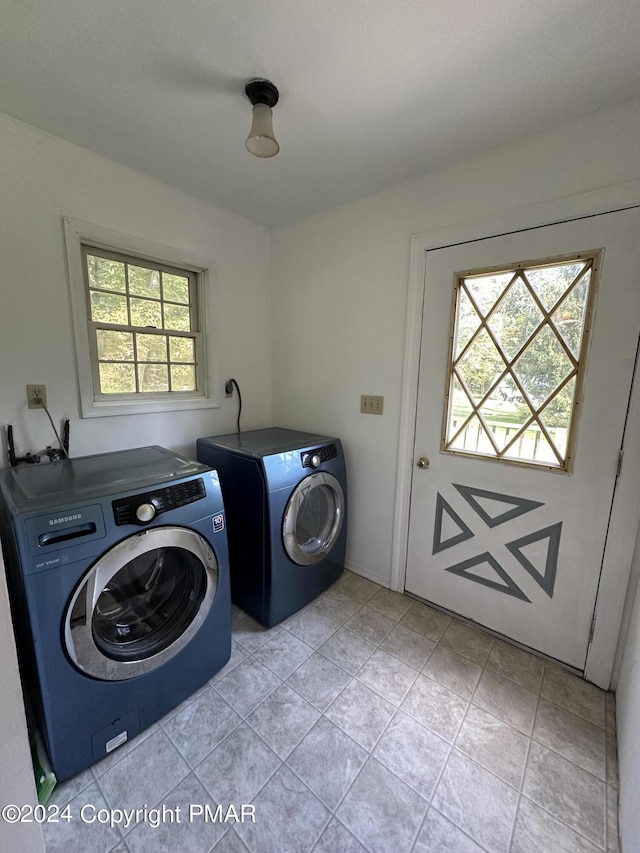 washroom with light tile patterned floors, laundry area, and washing machine and clothes dryer