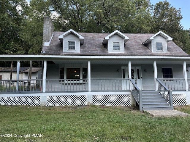 view of front of property featuring covered porch, a chimney, and a front lawn