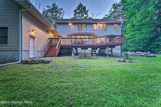 back of house featuring a lawn and a wooden deck