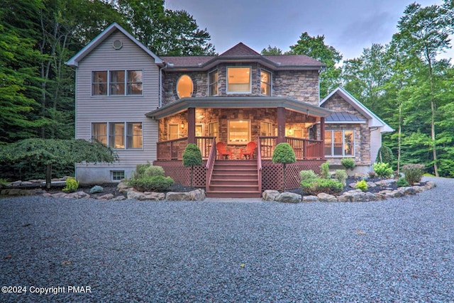 view of front of house with stone siding and covered porch