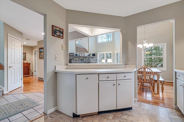 2181 Oak Hill Dr, Buck Hill Falls, PA 18323 - kitchen with light countertops, an inviting chandelier, and baseboards