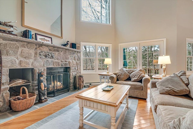 2181 Oak Hill Dr, Buck Hill Falls, PA 18323 - living room featuring a baseboard radiator, a high ceiling, wood finished floors, and a fireplace