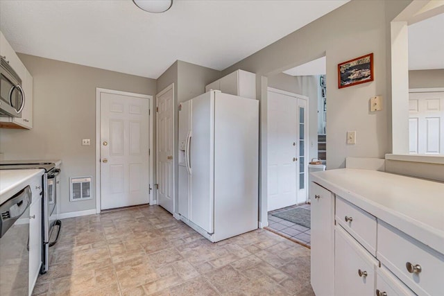 2181 Oak Hill Dr, Buck Hill Falls, PA 18323 - kitchen with baseboards, stone finish flooring, white cabinetry, light countertops, and stainless steel appliances