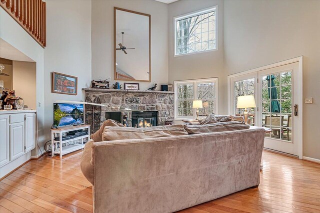 2181 Oak Hill Dr, Buck Hill Falls, PA 18323 - living area featuring light wood finished floors, plenty of natural light, a high ceiling, and a fireplace
