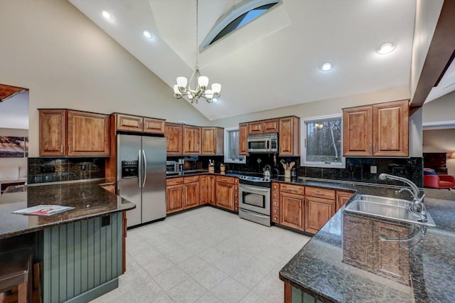 kitchen with brown cabinets, a notable chandelier, a sink, decorative light fixtures, and appliances with stainless steel finishes