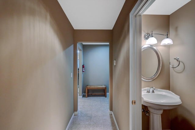 bathroom with tile patterned floors, baseboards, and a sink