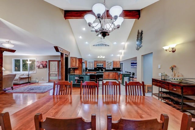 dining room with an inviting chandelier, beamed ceiling, light wood finished floors, and high vaulted ceiling