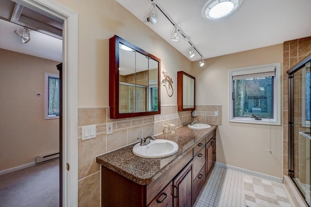 full bathroom featuring tile walls, a tile shower, baseboard heating, and a sink