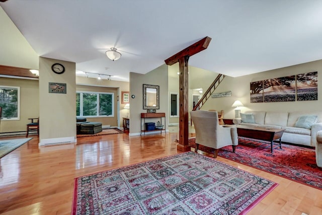 living area featuring electric panel, baseboard heating, lofted ceiling, and wood finished floors