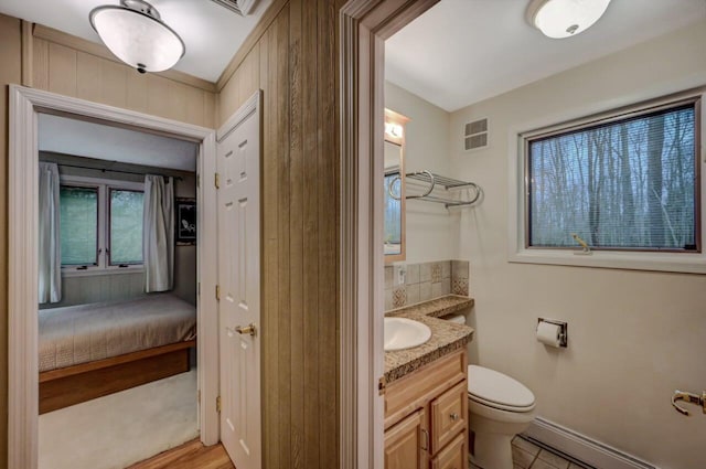 bathroom with visible vents, baseboards, toilet, baseboard heating, and vanity