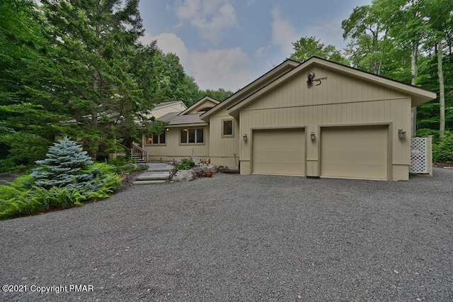 view of front of house featuring a garage and gravel driveway