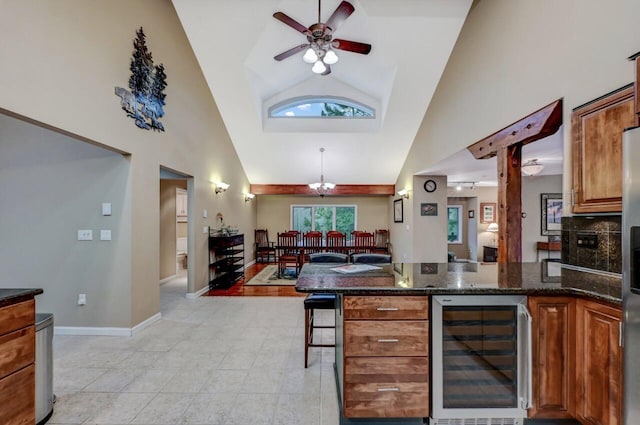 kitchen with beverage cooler, brown cabinets, a peninsula, and ceiling fan with notable chandelier