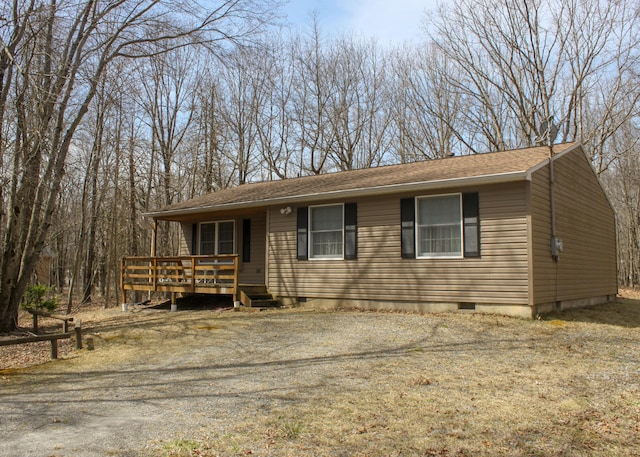 view of front of house featuring crawl space, a wooden deck, and roof with shingles