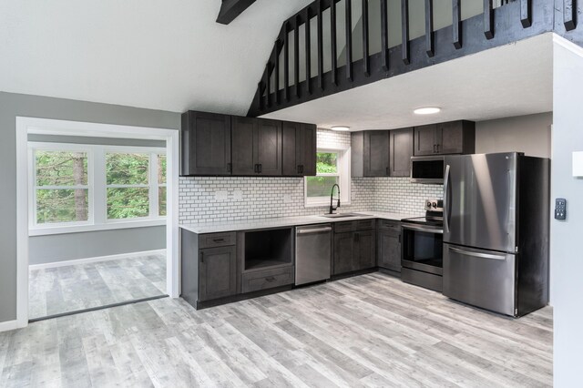 115 Tumbleweed Dr, Long Pond, PA 18334 - kitchen featuring appliances with stainless steel finishes, light countertops, tasteful backsplash, light wood finished floors, and high vaulted ceiling