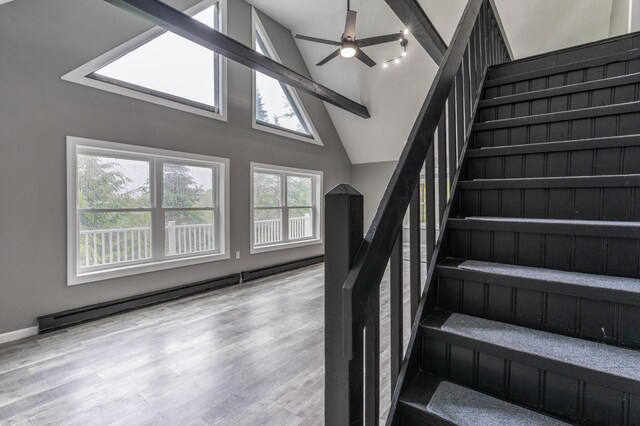 115 Tumbleweed Dr, Long Pond, PA 18334 - stairs featuring baseboard heating, a ceiling fan, wood finished floors, and high vaulted ceiling