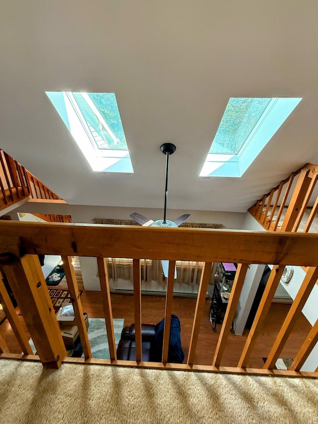 stairway with a ceiling fan and a skylight